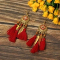 Nahaufnahme von Boho-Quastenohrringen mit Vintage-Blumenmustern und roten Fransen - Totem-Muster Rot