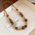 Close-up of tiger eye stone beads and gold twisted metal rings with lobster clasp detail - Twisted Woven Ring Style (10#) / Gold