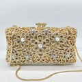 Clutch da sera dorata con motivo floreale traforato, strass lucidi e catena in metallo - Oro / Zirconia Bianca