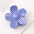 Detailed view of a blue and white checkered flower claw clip on an open book - Yellow/White Plaid Flower Clip
