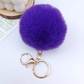 Detailed view of a purple faux fur pompom keychain with a gold-tone metal spring ring clasp - Deep purple