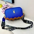 Close-up of royal blue grained PU crossbody bag with unique brown wave texture and gold hardware - Dark Blue