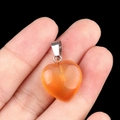 Pendentif cœur en agate orange 16mm avec fermoir argenté présenté sur une main - Agate rouge