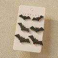 Three pairs of matte black bat stud earrings on white display card for Halloween - Black Bat Stud Earring Set (3)