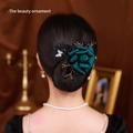 Detail van donkergroene satijnen roos haaraccessoire met vlinder op vrouw kapsel - Groene Bloem Knot Maker