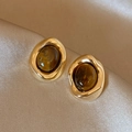 Vintage goldene Ohrringe mit ovalen Tigerauge-Steinen auf champagnerfarbenem Seidenhintergrund - Retro Metall Tigerauge Stecker / Silbernadel Gold Braun Ovales Tigerauge (HE29901)