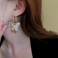 Close-up of elegant gold butterfly earrings encrusted with sparkling cubic zirconia crystals - Gold