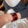 Primo piano di un ampio bracciale a polsino aperto in acetato tartarugato scuro su modella - Stile 53 - Color Caffè Scuro