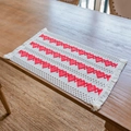 Rectangular cream cotton linen placemat with red woven heart patterns and fringe edges - Three Rows of Hearts