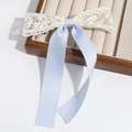Close-up of light blue silk ribbon and cream lace bow hair clip on a wooden box - Blue Lace