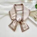 Elegant cream silk-feel twilly scarf with brown borders tied in a bow on a white desk - Khaki Edge