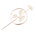 Detail der goldenen abstrakten Haarnadel mit minimalistischen künstlerischen Gesichtskonturen - Gold