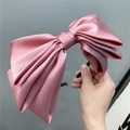 Detail of multi-layered satin bow headband in dusty pink with a silky glossy texture - Pink