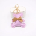 Close-up of pink PU leather bear keychain with brown bow and golden metal lobster clasp - Taro Purple