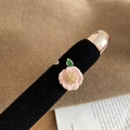 Macro d'une bague camélia plaquée or 14K avec feuilles vertes sur support en velours noir - Bague en Émail Camélia Rose (WR558)