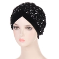Detailed view of black velvet turban hat featuring intricate shimmering sequins and pleated design - Black