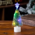 Detail eines Mini-Weihnachtsbaums mit bunten LED-Lichtern auf Holzoberfläche - Buntes Licht - Klein