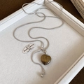 Détail du pendentif cœur œil de tigre sur chaîne serpent argentée avec fermoir - Style Coeur