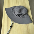 Detalle de un sombrero de sol gris con ala ancha, tejido de nailon y barbijo ajustable - Talla única / Gris