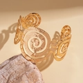 Macro shot of gold wide open cuff bracelet featuring hammered texture and hollow spiral patterns - Gold