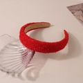 Close-up of red plaid woven headband on a decorative shell tray with soft lighting - Solid Red