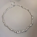Dettaglio della texture in metallo liquido irregolare e chiusura della collana d'argento - Argento