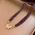 Detail of vintage beaded necklace with purple beads and gold butterfly pendant on a tray - Deep Purple/Butterfly Pendant