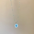 Collana dorata con ciondolo ovale in turchese e piccole perle blu sulla catena - Oro-Blu