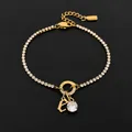 Stainless steel initial letter bracelet with sparkling rhinestone charm in gold finish. - Letter E