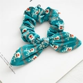 Detail of turquoise plush Christmas scrunchie with reindeer patterns and bow design - Green Elk Velvet