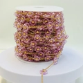 Dettaglio macro di catena dorata fatta a mano con perle a fiori viola su rocchetto - Oro Viola