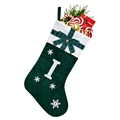 Detail of green velvet Christmas stocking with white embroidered letter I and gift fillings - Green I