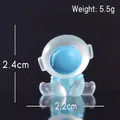 Leuchtende Mini-Astronautenfigur aus Harz in Hellblau, 2,4 cm hoch mit Maßangaben - Spagat Astronaut