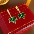 Detailed macro shot of green zircon maple leaf earrings with gold plating finish - Green Maple Leaf Style (Gold Plated)