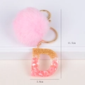 Portachiavi con pompon rosa e ciondolo a lettera D in resina glitter dorata - Lettera D
