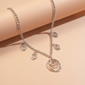 Detailed macro view of silver floral spiral pendants on a minimalist metallic link necklace - Necklace / Silver