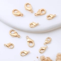 Close-up of golden lobster clasps for DIY jewelry making on a minimalist white surface - 12mm / Champagne KC Gold