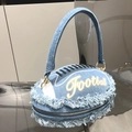 Macro shot of football-shaped denim clutch with frayed edges and embroidered football text - Denim Blue B