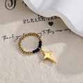 Elastic beaded daisy ring with gold star pendant and black beads in a minimalist style - Four-Pointed Star Charm