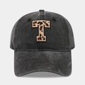 Detail of embroidered leopard print letter T on washed black cotton baseball cap - Letter T