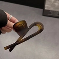 Large amber brown matte resin shark hair claw clip held by hand for thick hair - Matte Amber