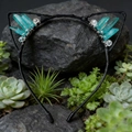 Detailed shot of cat ear headband with cyan crystal clusters on black frame in nature - Green Cat Ears