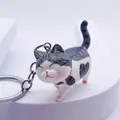 Cute cartoon cat keychain with gray stripes and heart pattern on a white platform - Grey Spotted