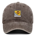 Close-up of sun and cloud embroidery on vintage washed cotton baseball cap texture - Coffee