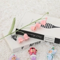 Close-up of handmade crochet pink lily of the valley flower resting on a book - Single Stem 2 Buds 5 Flowers / Pink