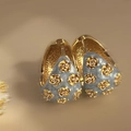 Macro detail of vintage gold C-shape hoop earrings with light blue enamel and floral patterns - Hoop-Gold-Blue