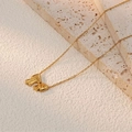 Elegante goldene Halskette mit Schleifenanhänger auf minimalistischem Stein - Jm2168