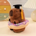 Cute capybara plush toy with graduation cap and purple donut ring accessory - Donut / Brown