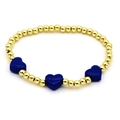 Detailed macro view of golden beaded bracelet with three dark blue enamel heart charms - Sapphire Blue
