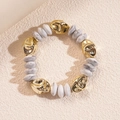 Dettaglio di perline dorate irregolari e perline rotonde effetto marmo su un braccialetto - Bracciale-Bianco Grigio